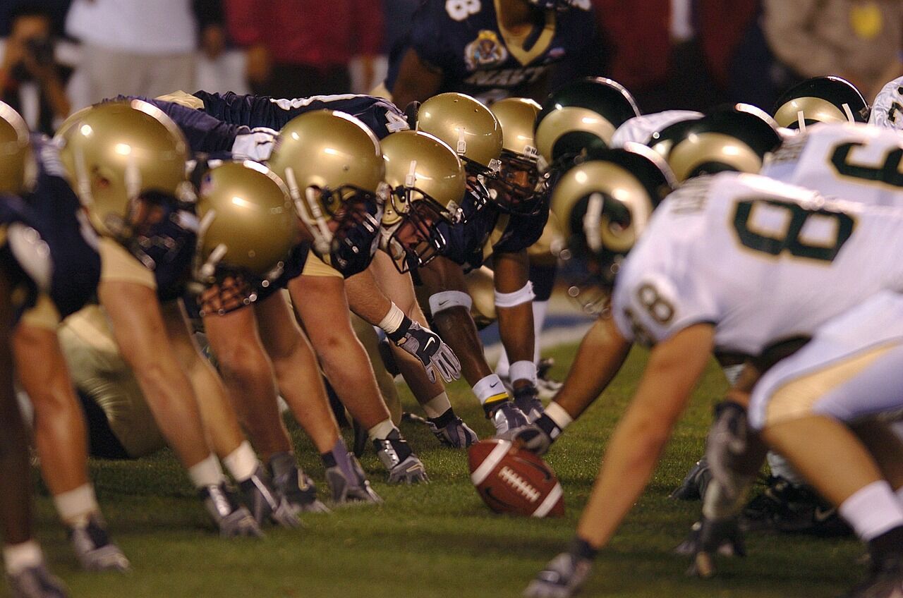 College football players get ready to start a play